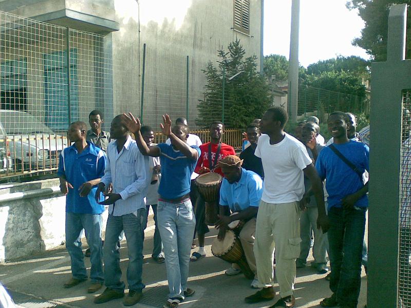 170720081517.jpg - Gli immigrati del Centro Fernandes salutano gli scout alla porta del Centro.